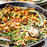 green bean casserole in a skillet with a serving spoon.