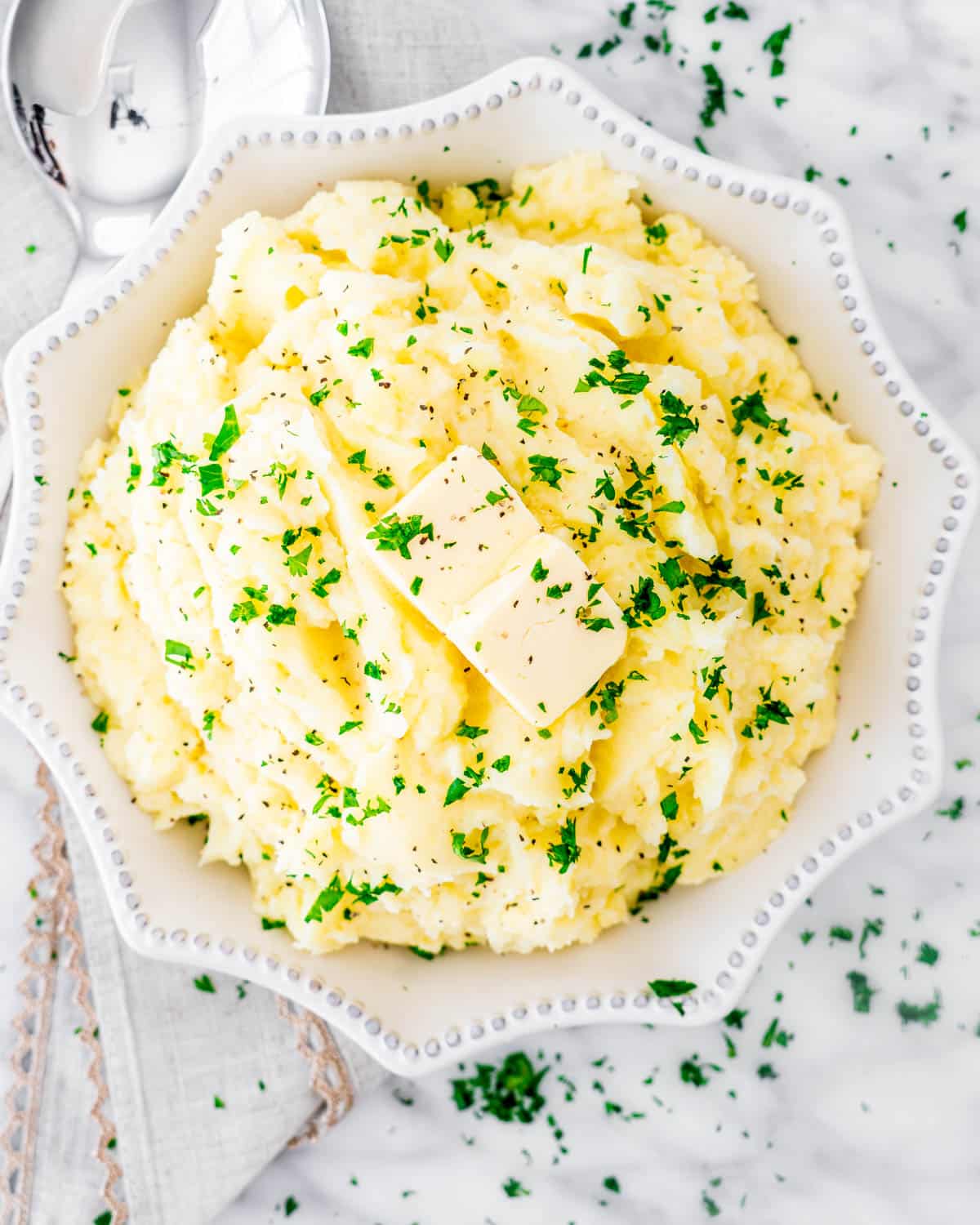 instant pot mashed potatoes with a pat of butter in a white bowl