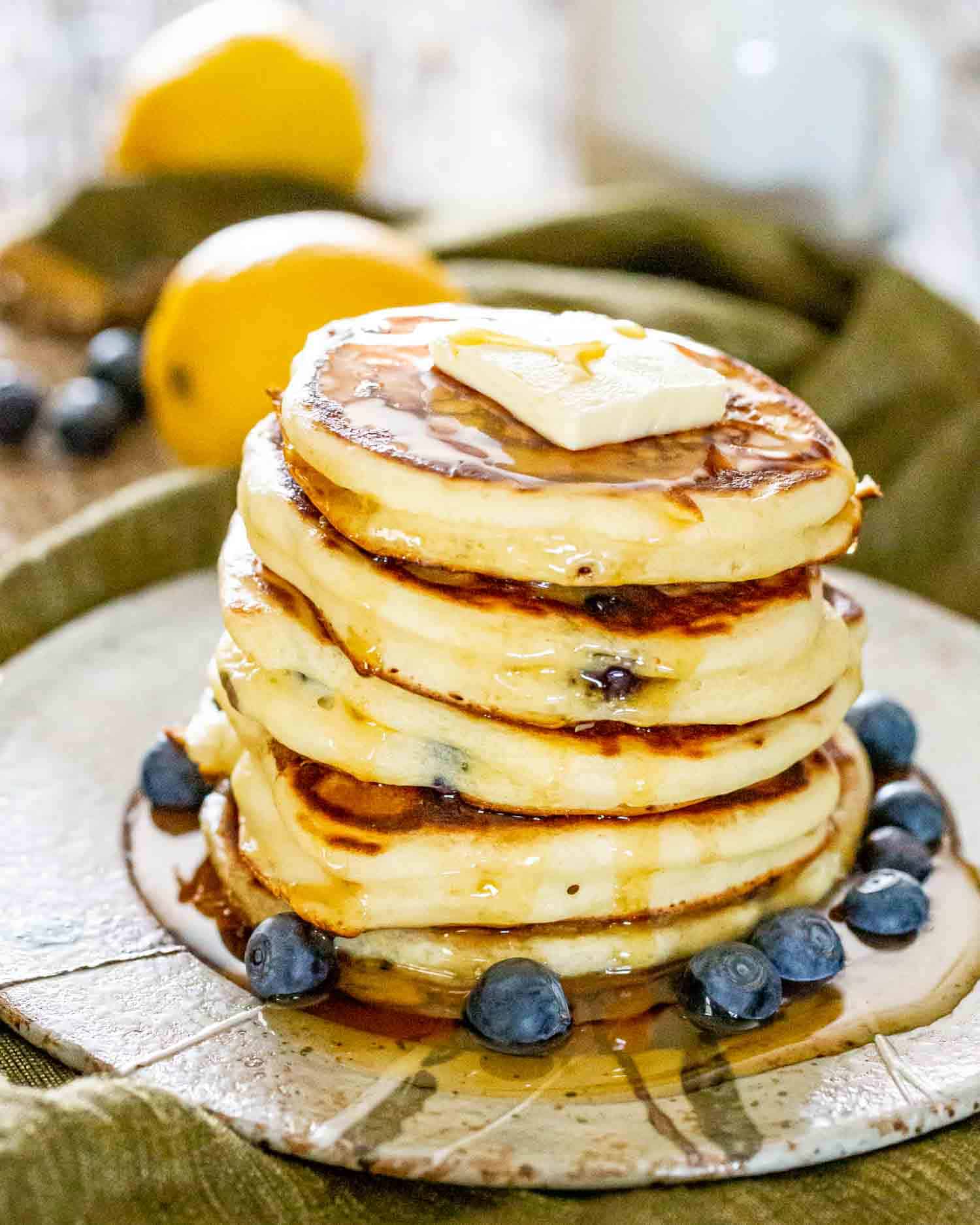 a stack of lemon blueberry ricotta pancakes on a plate.