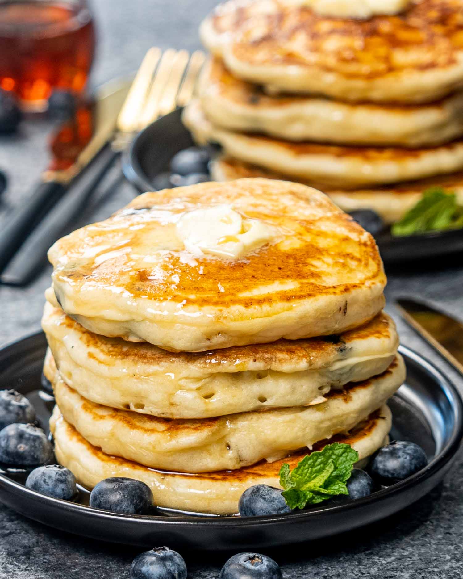a stack of lemon blueberry ricotta pancakes on a plate.