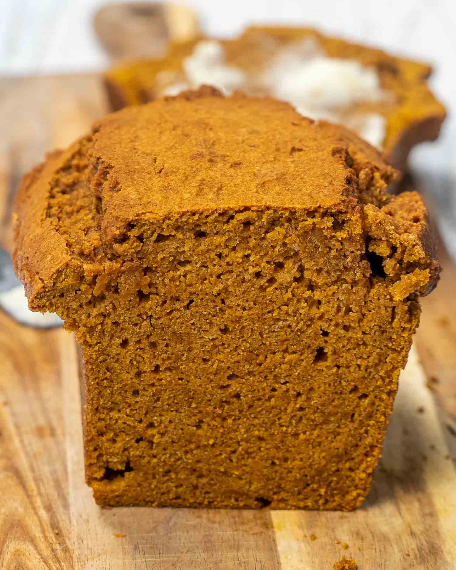 a loaf of pumpkin bread on a cutting board with a few slices cut out of it.