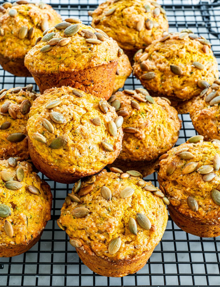 side view shot of pumpkin zucchini muffins on a cooling rack
