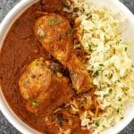 Overhead view of chicken paprikash with egg noodles and creamy paprika sauce in a white serving bowl.
