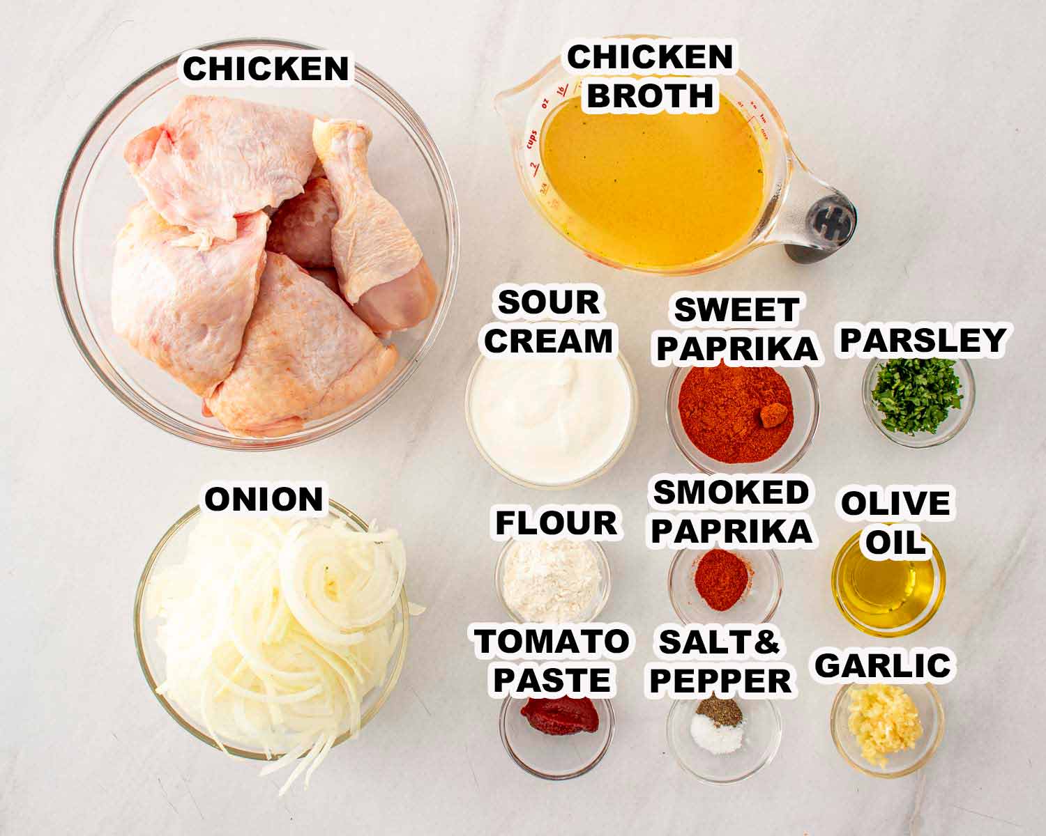 Ingredients for chicken paprikash including chicken thighs, onions, paprika, sour cream, garlic, tomato paste, and chicken broth.