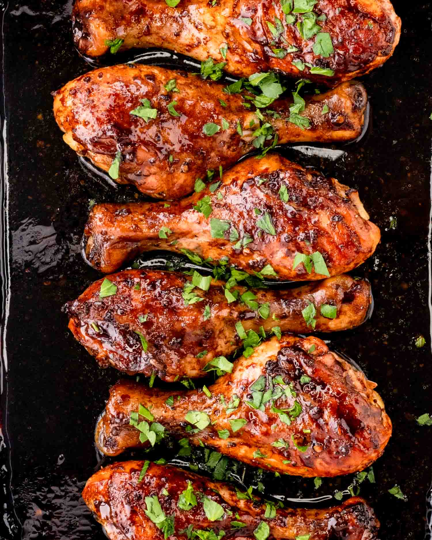 honey mustard chicken garnished with parsley in a roasting pan.