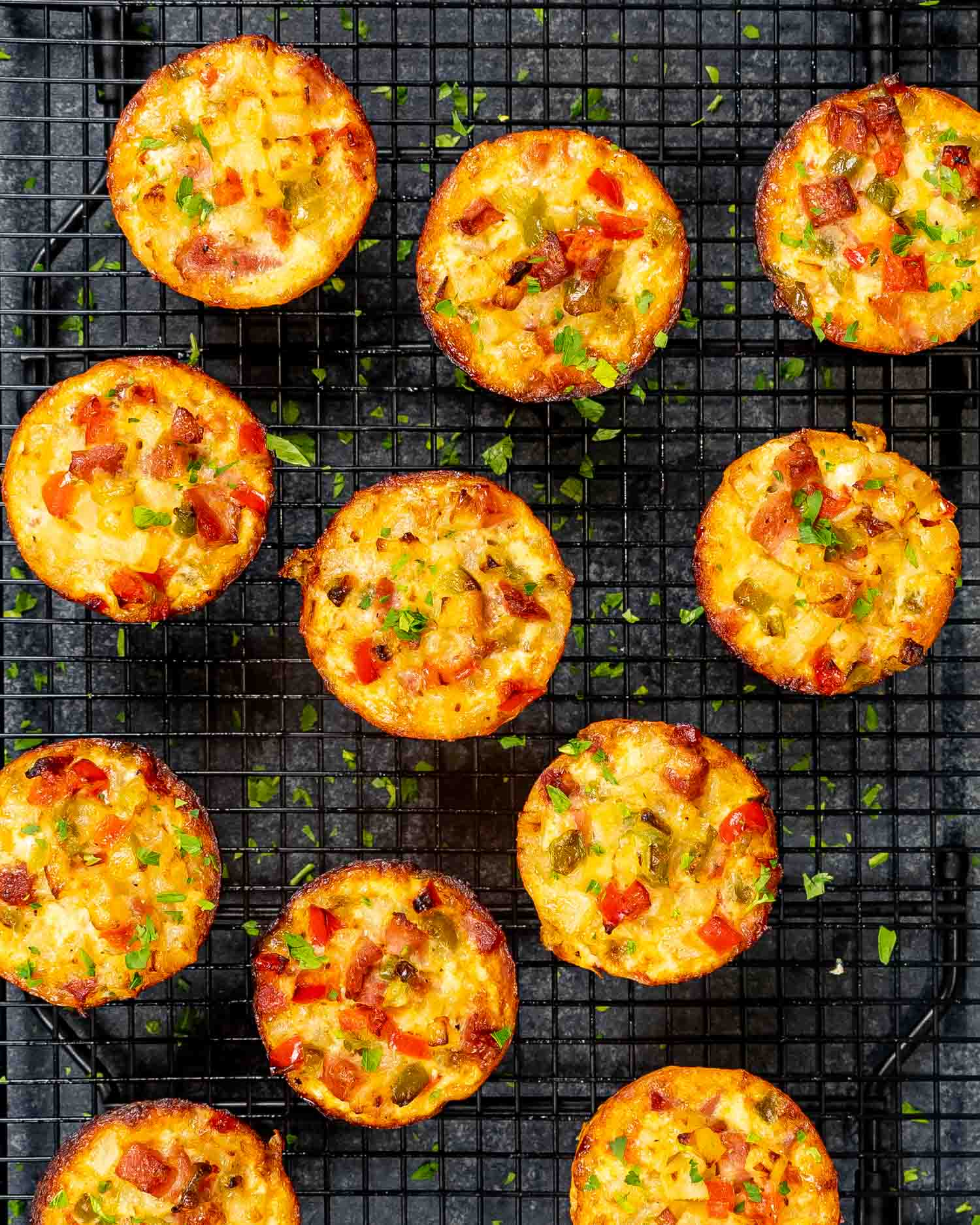 leftover ham and cheese breakfast muffins on a black cooling rack.