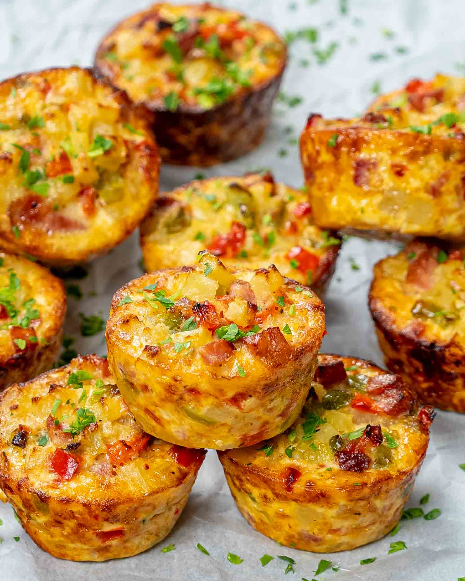 a few leftover ham and cheese breakfast muffins on a table garnished with some parsley.