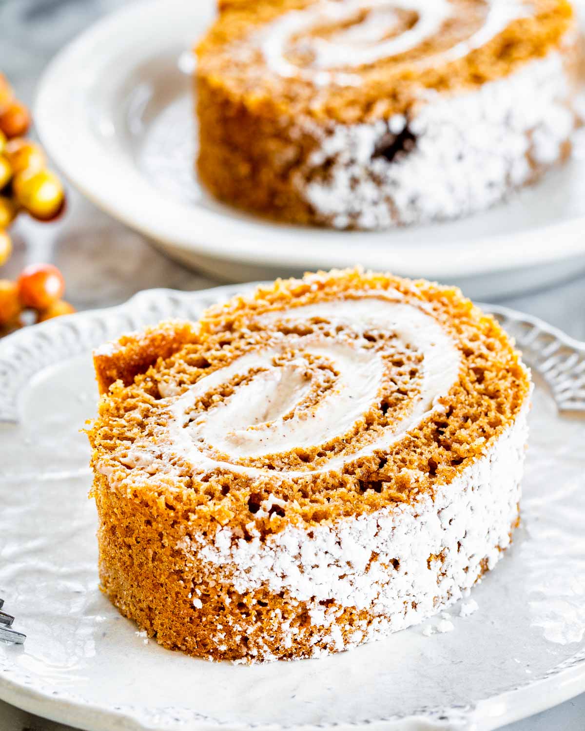 a slice of pumpkin roll on a white plate.