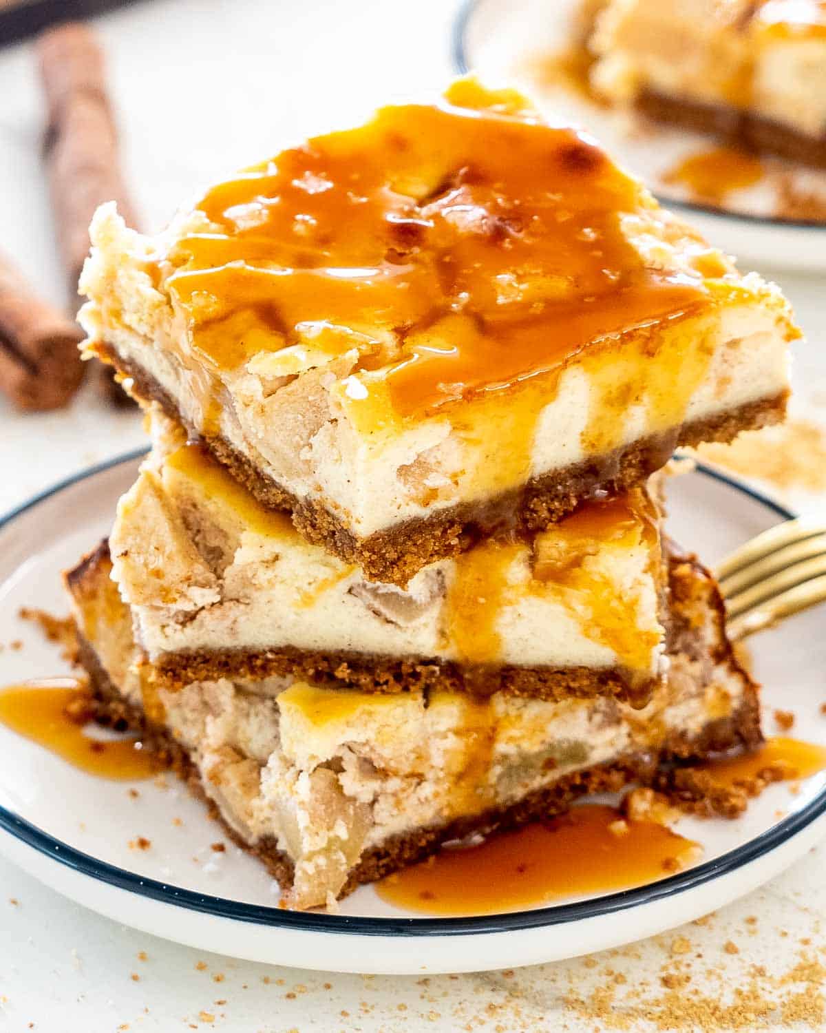a stack of 3 apple pie cheesecake bars drizzled with salted caramel.