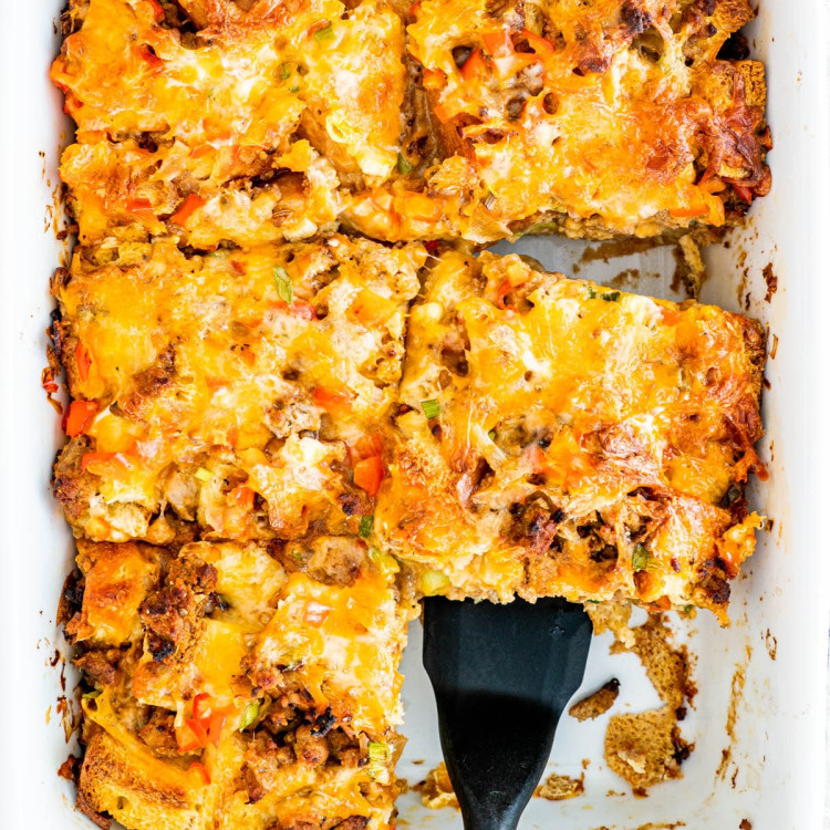 overhead shot of a spatula scooping up a piece of breakfast casserole from the pan