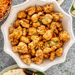 overhead shot of chicharrones de pollo in a white bowl.