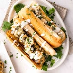 two chicken spiedies on a plate drizzled with garlic sauce.