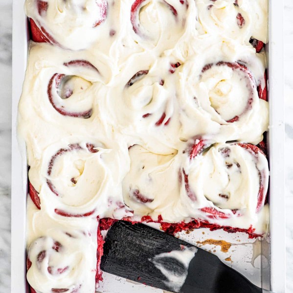 overhead shot of a pan filled with red velvet cinnamon rolls with two missing