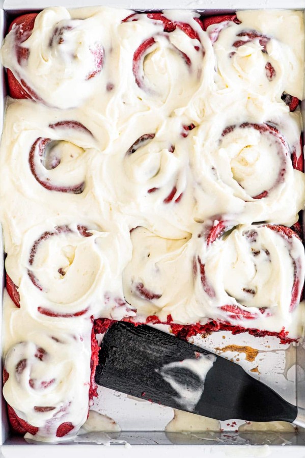 overhead shot of a pan filled with red velvet cinnamon rolls with two missing
