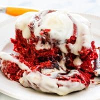 side view shot of a red velvet cinnamon roll on a plate