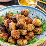 romanian meatballs in a clay bowl garnished with dill.