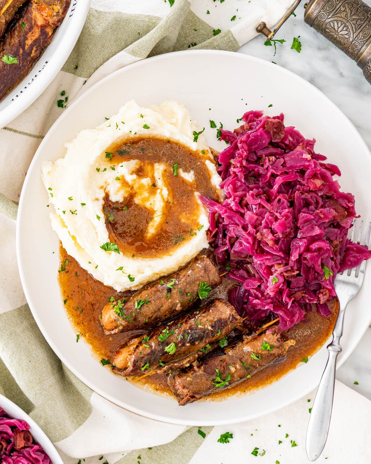 overhead shot of beef rouladen and rotkohl with gravy on a plate