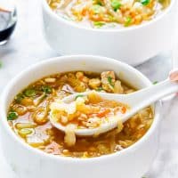 a soup spoon taking a bite of egg roll soup from a bowl