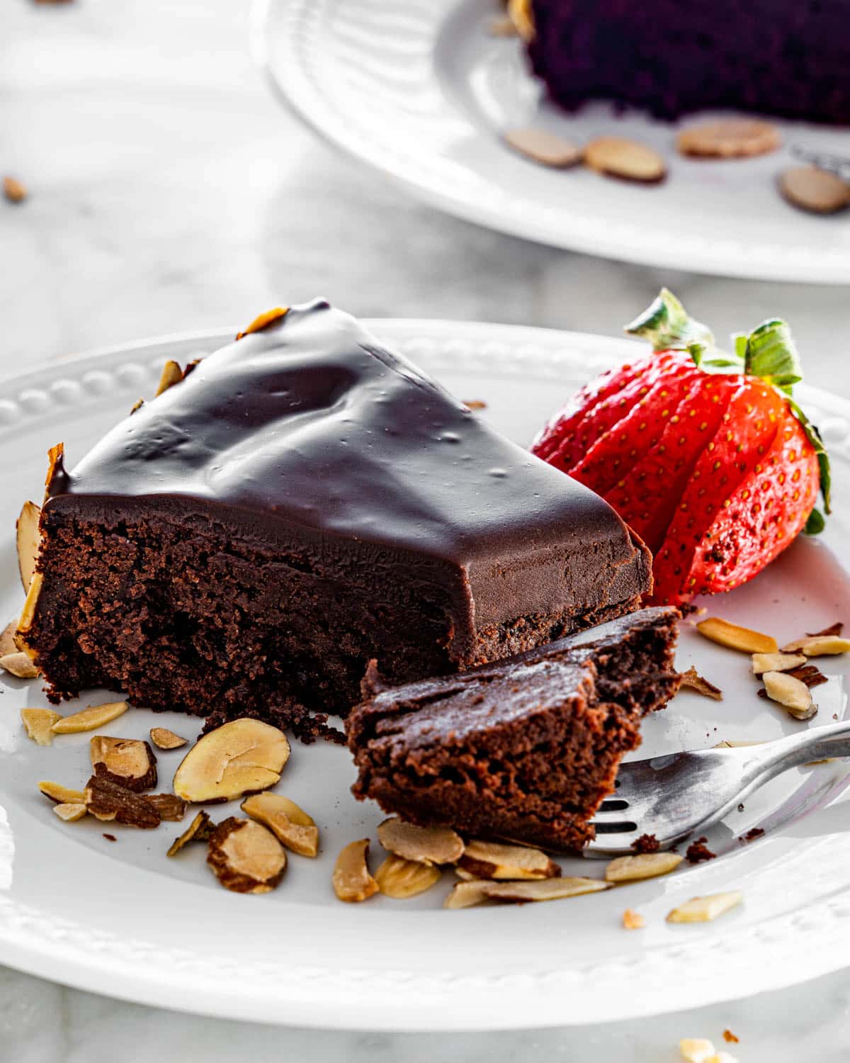 a slice of flourless chocolate cake on a white plate