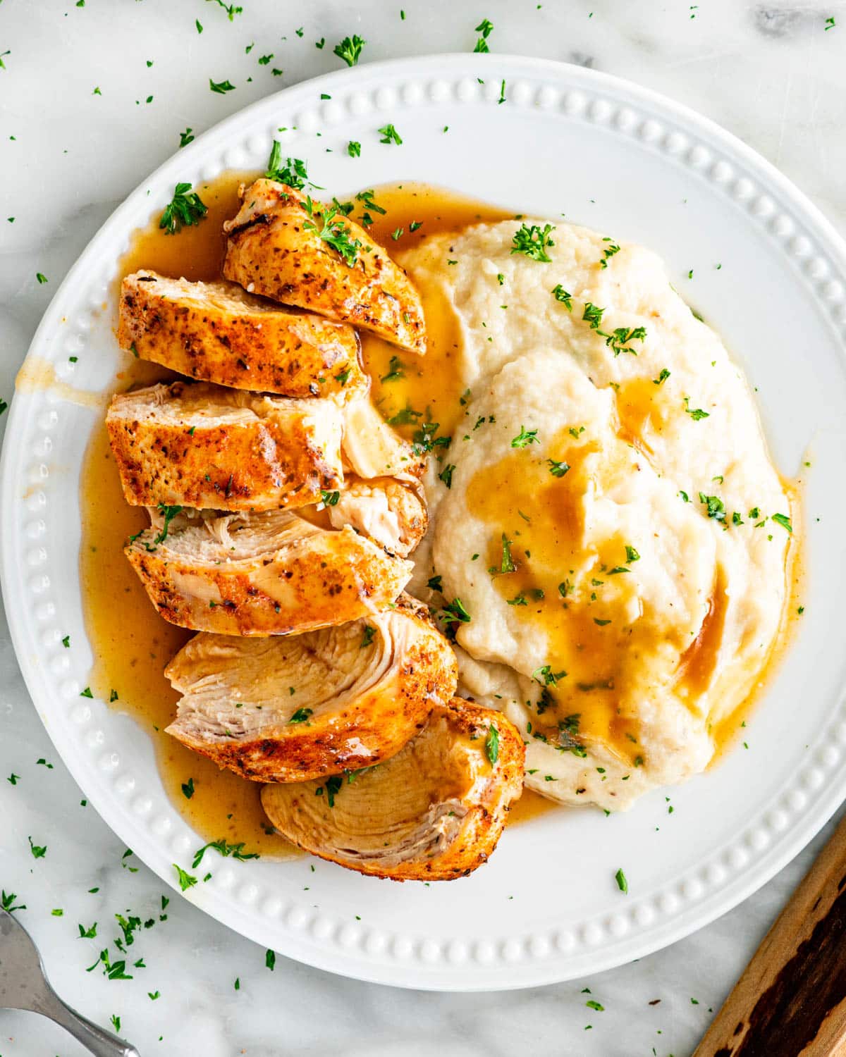 overhead shot of a sliced chicken breasts with mashed cauliflower and gravy
