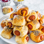 a plate full of pigs in a blanket stacked on top of each other