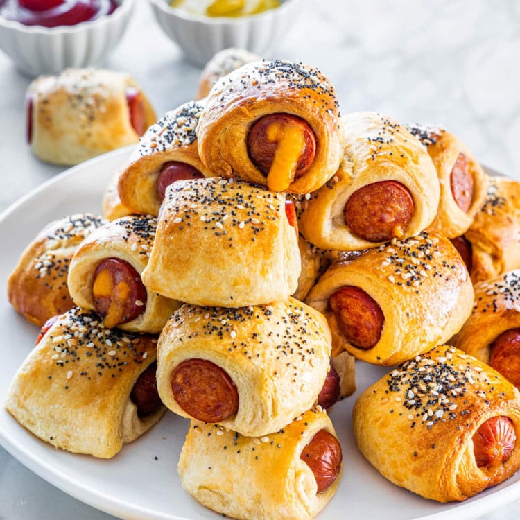 a plate full of pigs in a blanket stacked on top of each other