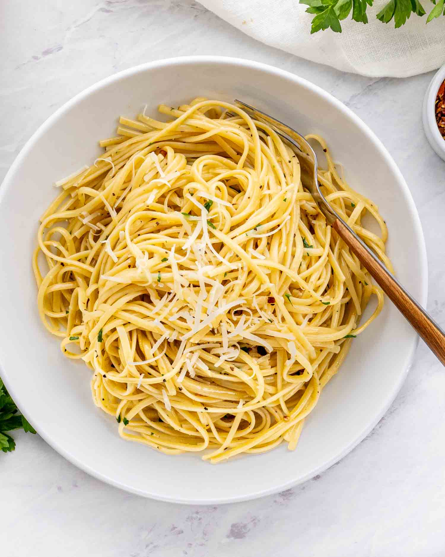 a serving of aglio e olio in a white bowl.