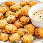 side view shot of a plate full of fried pickles with a side of chipotle aioli