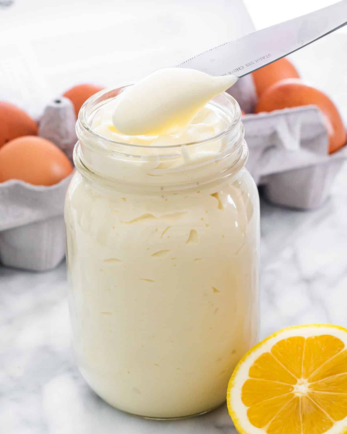 homemade mayonnaise in a jar with a knife in it