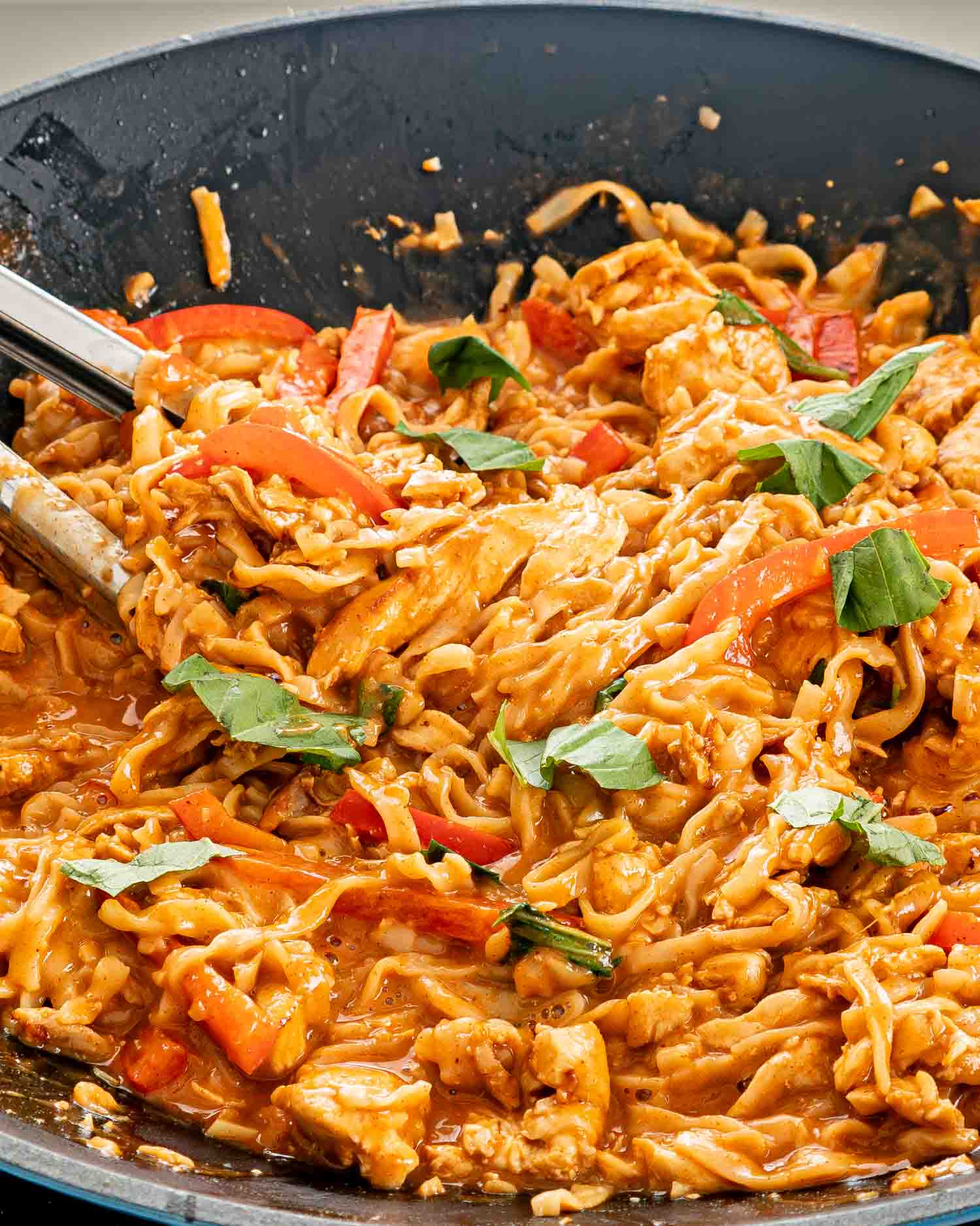 freshly made spicy peanut noodles in a wok.