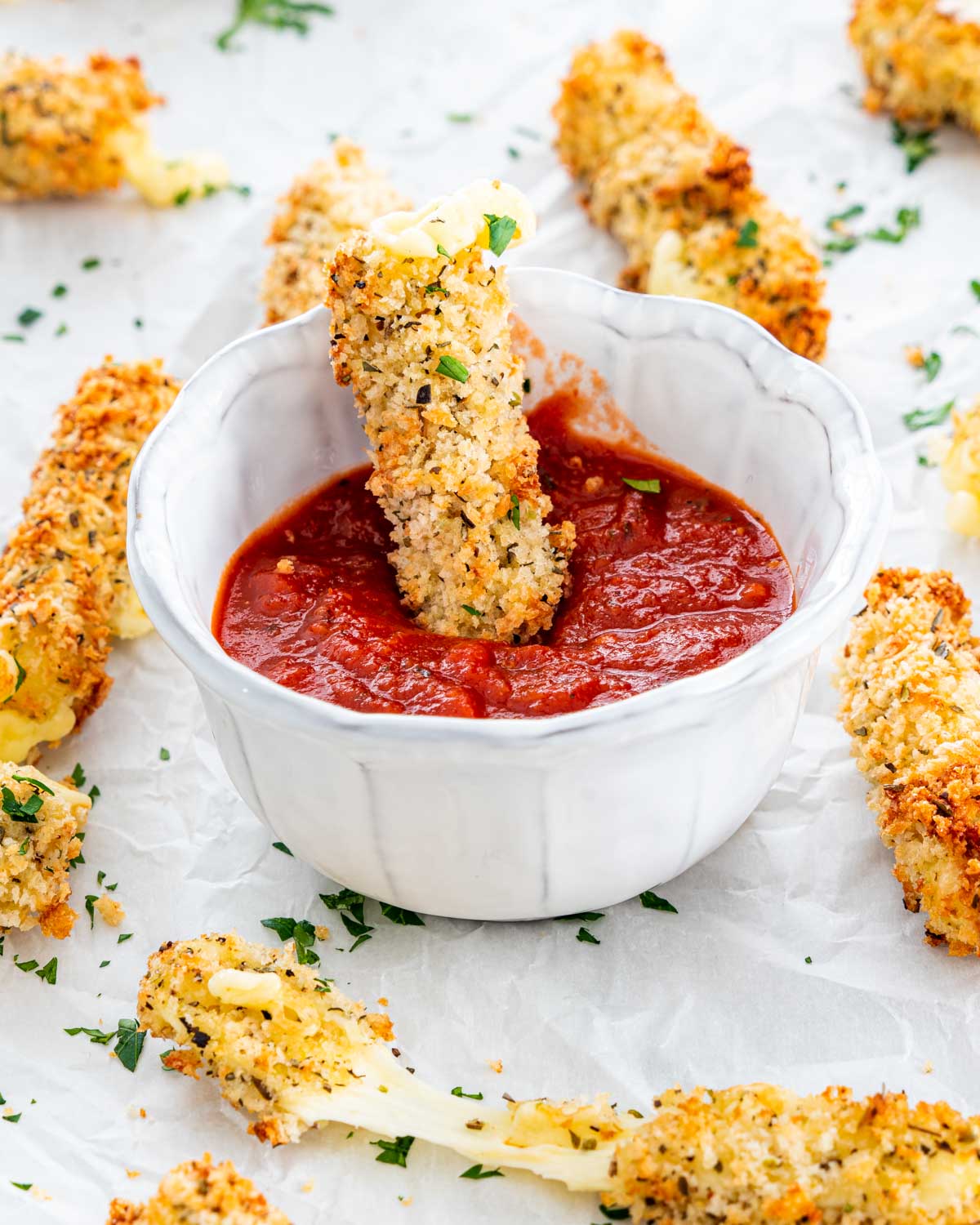 a bowl with marinara sauce with a mozzarella stick in it 