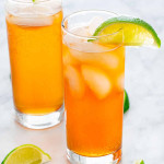 Two dark and stormy cocktails in tall glasses, garnished with lime wedges