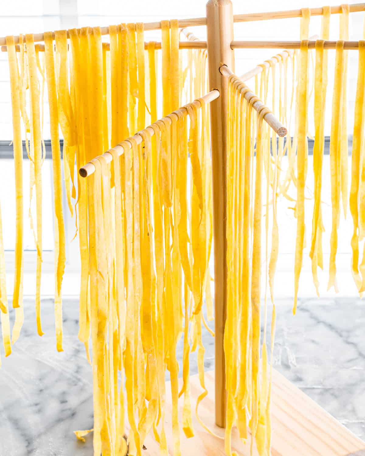fresh homemade pasta on a pasta drying rack