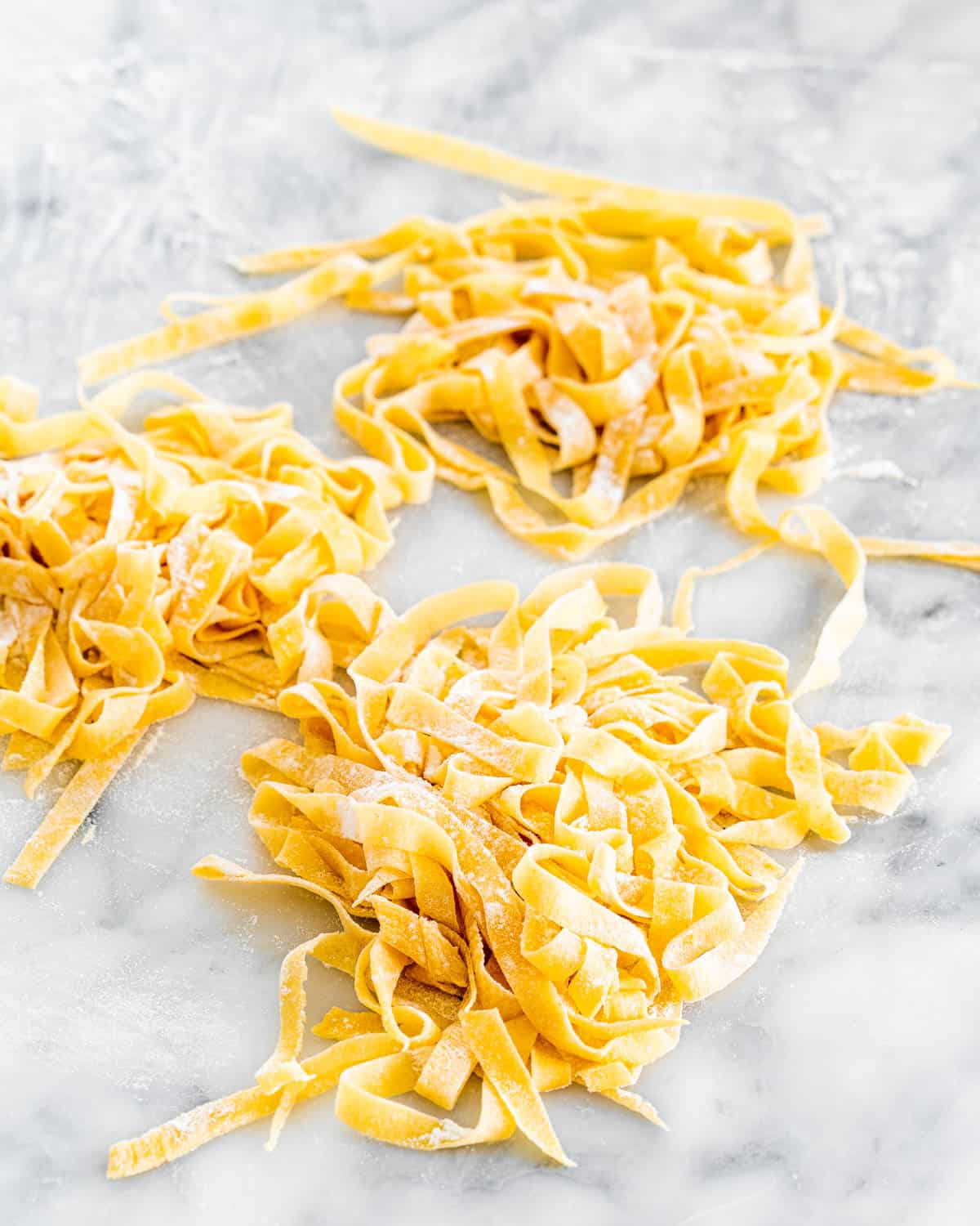 fresh homemade pasta on a floured work surface