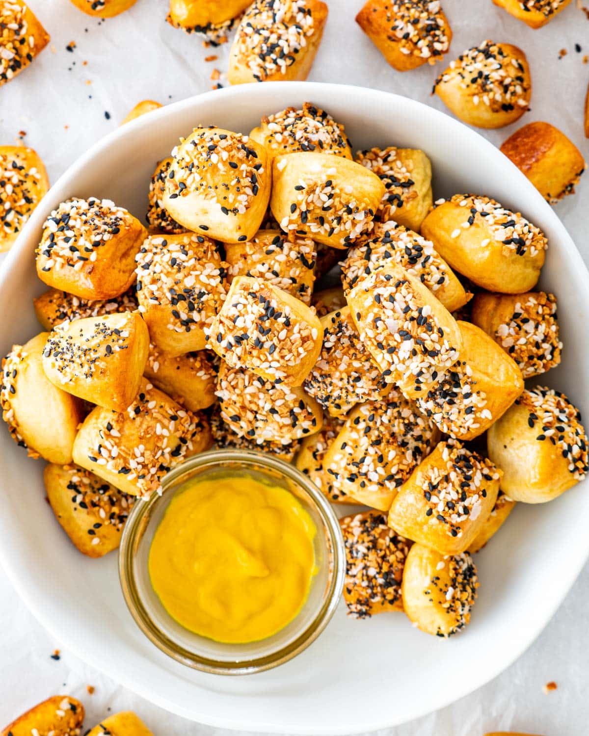 overhead shot of pretzel bites in a white bowl with mustard in a small bowl