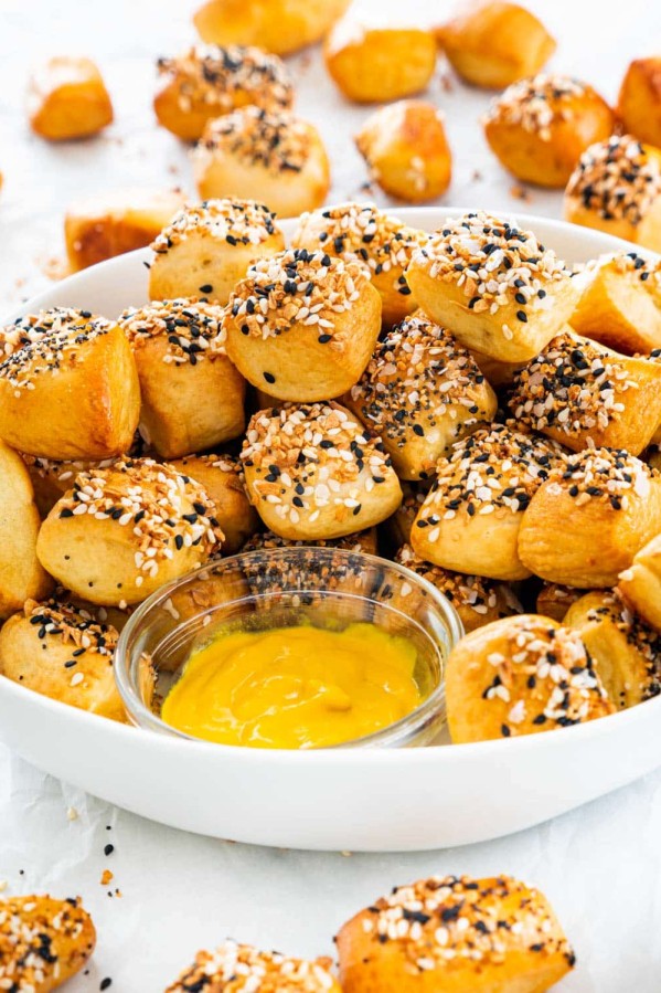a bowl of pretzel bites with a side of mustard to dip