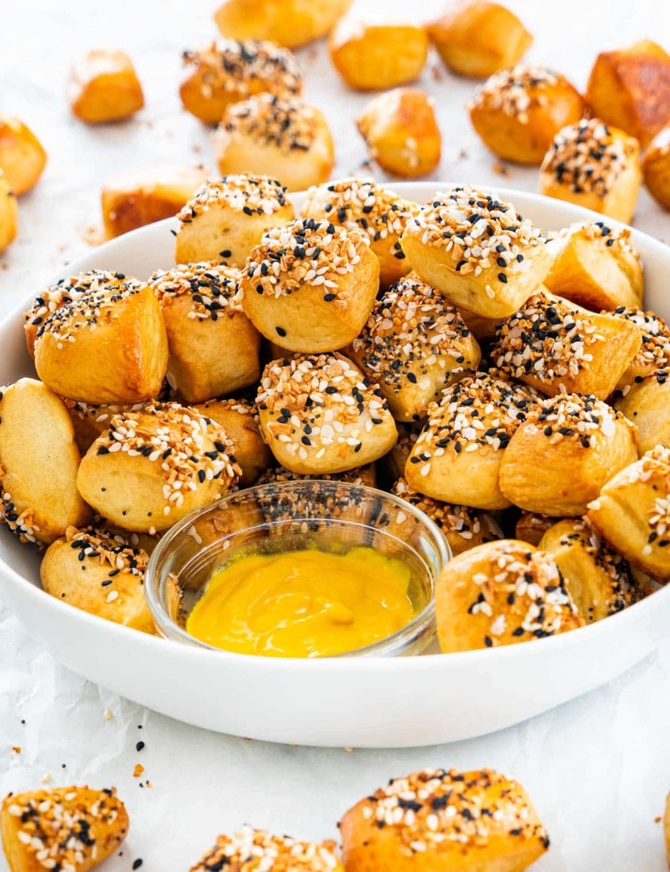 a bowl of pretzel bites with a side of mustard to dip