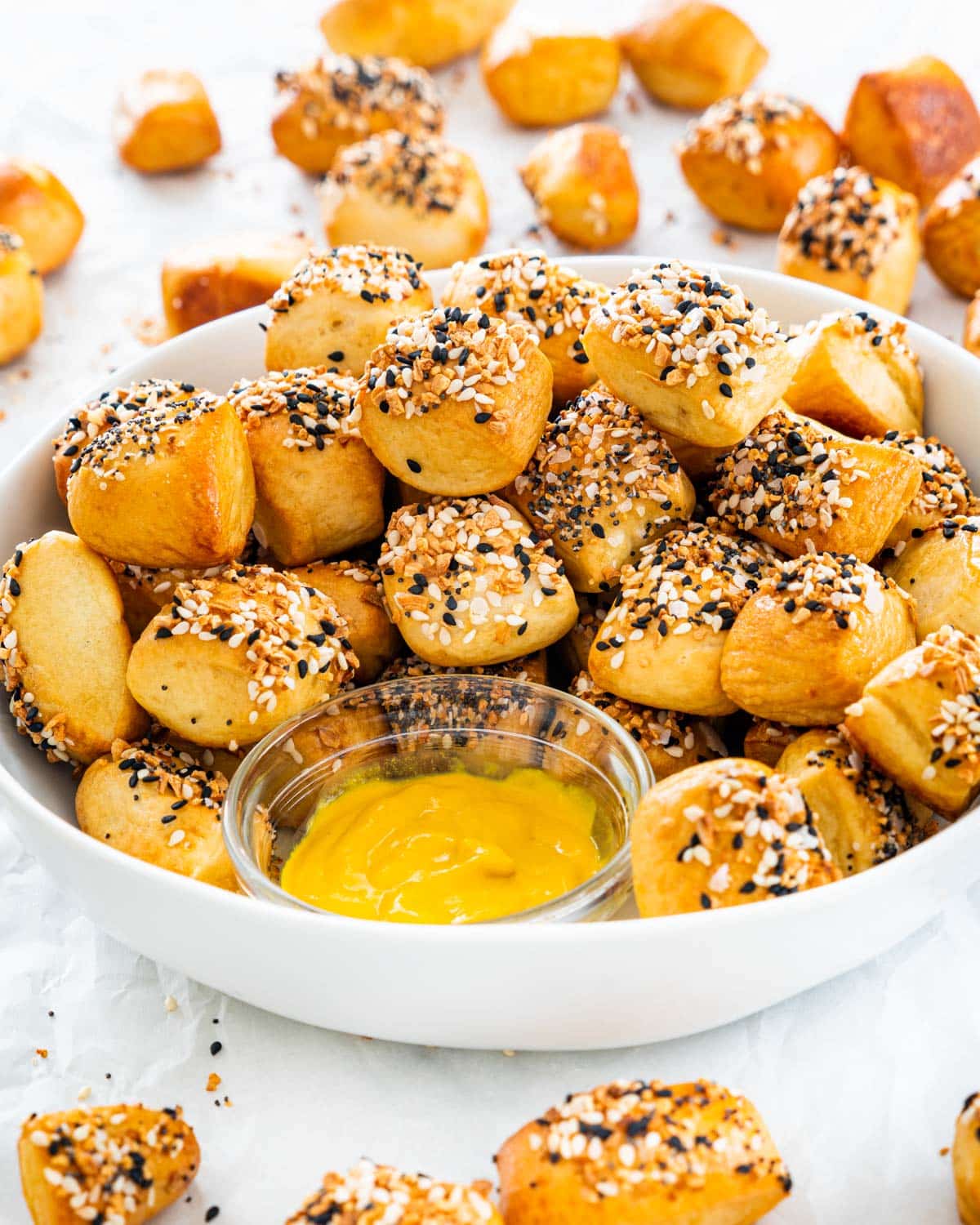 pretzel bites in a white bowl with a side of mustard