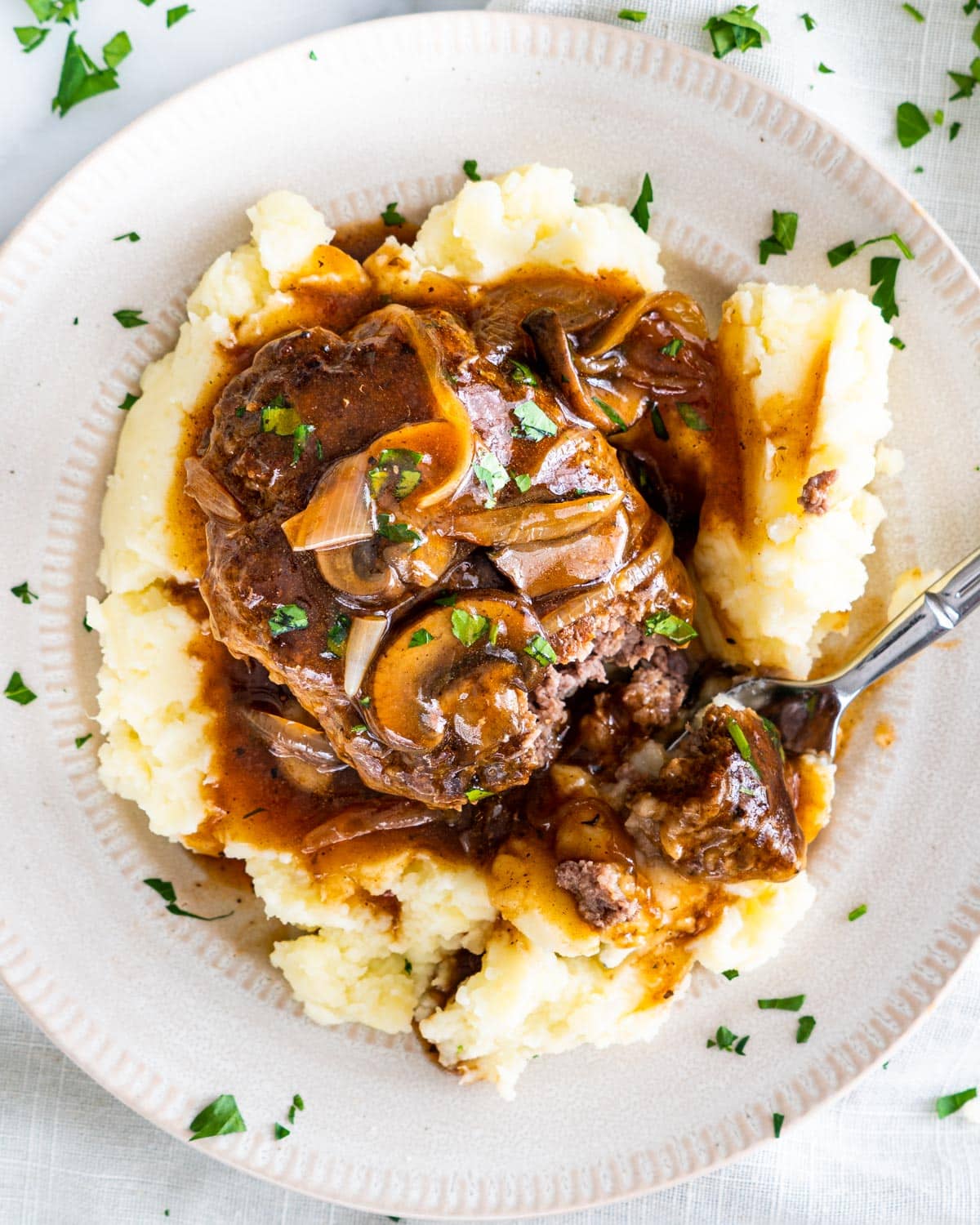 overhead shot of salisbury steak with mushroom gravy over a bed of mashed potatoes