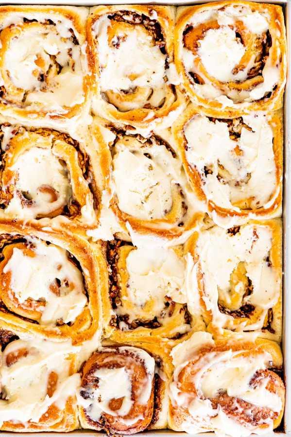 overhead shot of apple pecan cinnamon rolls fresh out of the oven iced with cream cheese icing