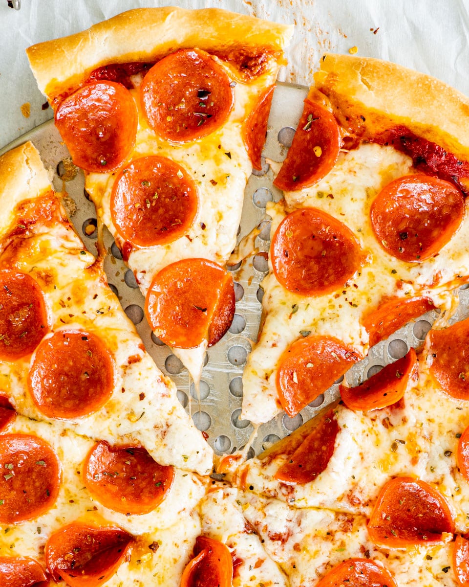 overhead shot of a pepperoni pizza sliced
