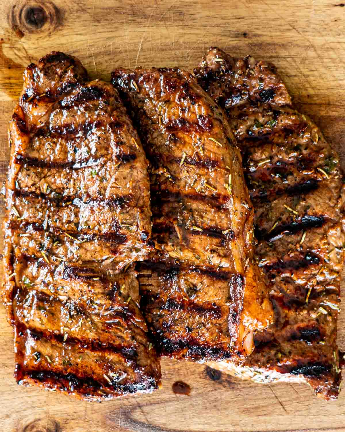 overhead shot of 3 grilled steak on a cutting board
