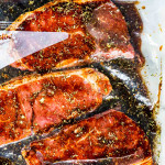overhead shot of 3 steaks in a marinade in a ziploc bag