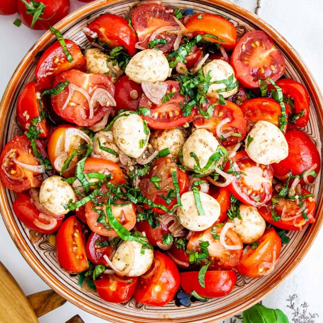 overhead shot of tomato basil salad with bocconcini in a bowl