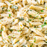 closeup shot of creamy goat cheese pasta in a pasta bowl garnished with fresh parsley and parmesan cheese