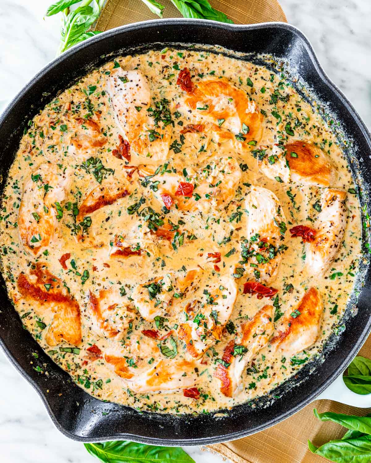 overhead shot of creamy tuscan chicken in a blue skillet 