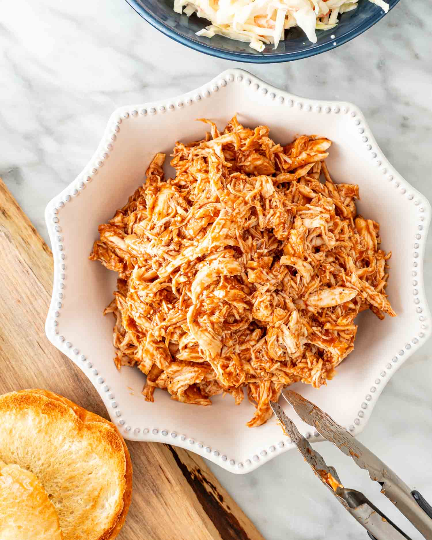 bbq pulled chicken in a white bowl that was made in an instant pot.