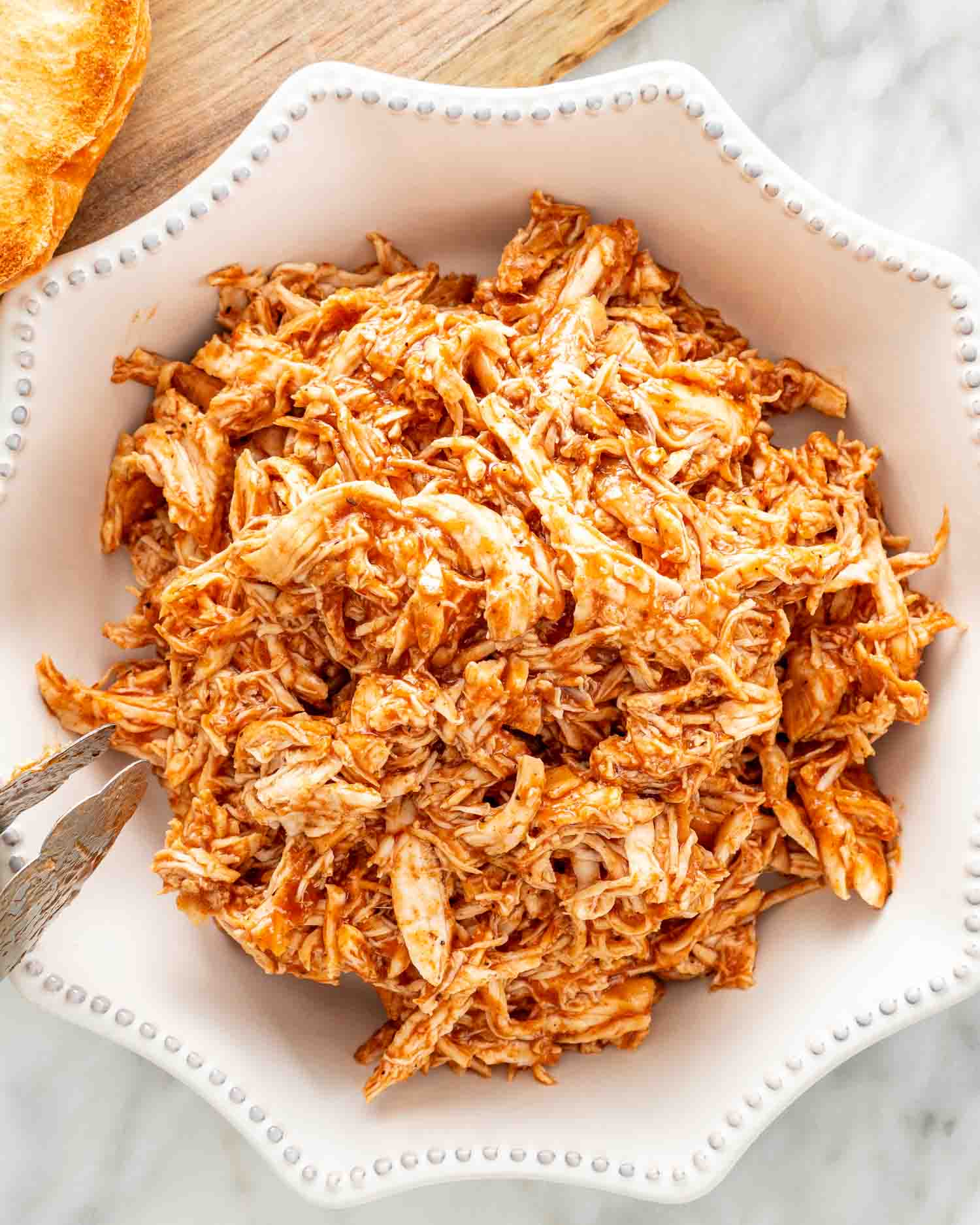bbq pulled chicken in a white bowl that was made in an instant pot.