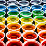 a rainbow of jello shots in small plastic cups