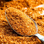 closeup sideview shot of a tablespoon with bbq dry rub surround by it